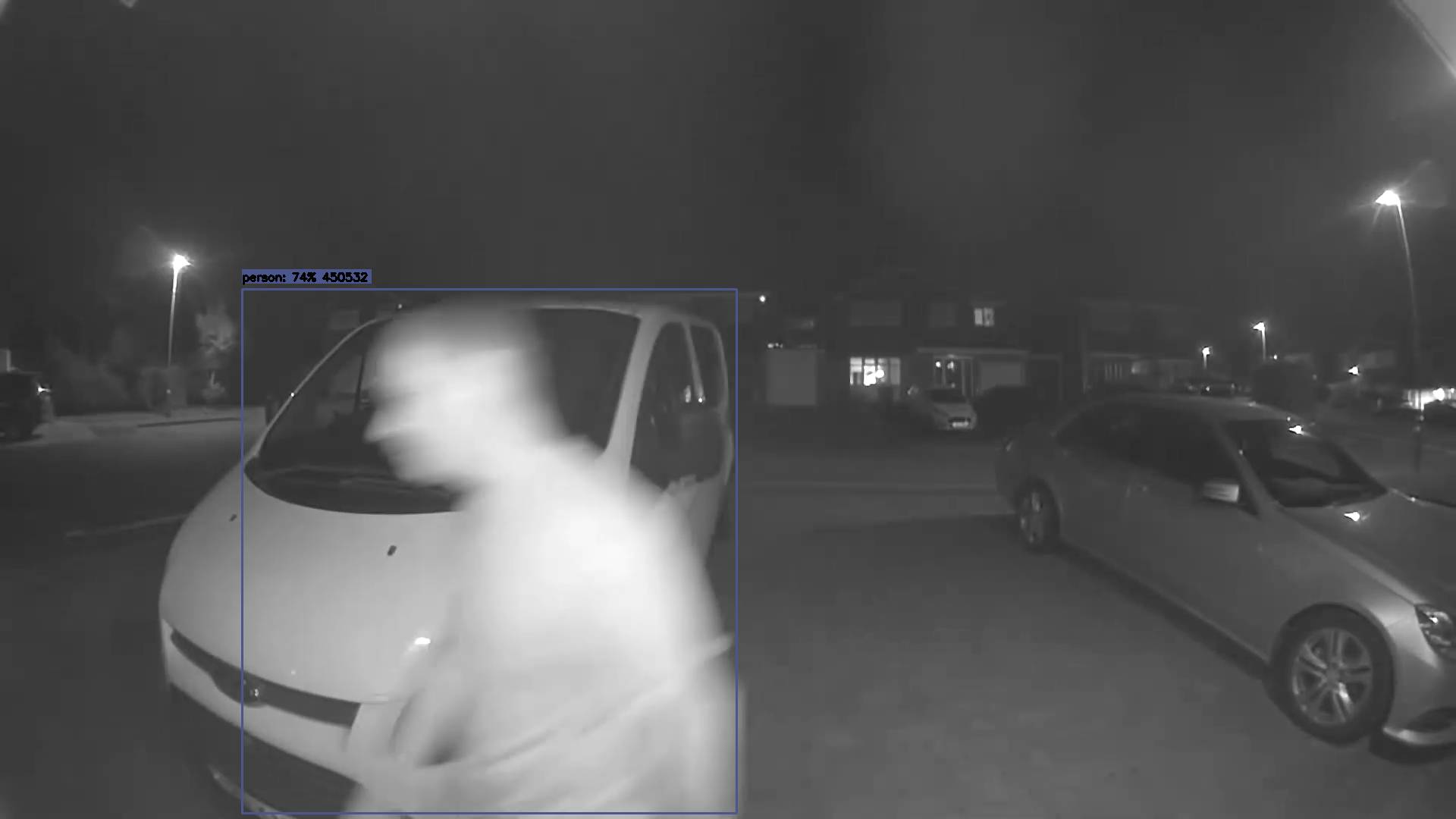 An AI detection: a person outlined by a bounding box on the night-time driveway, scored at 84% confidence
